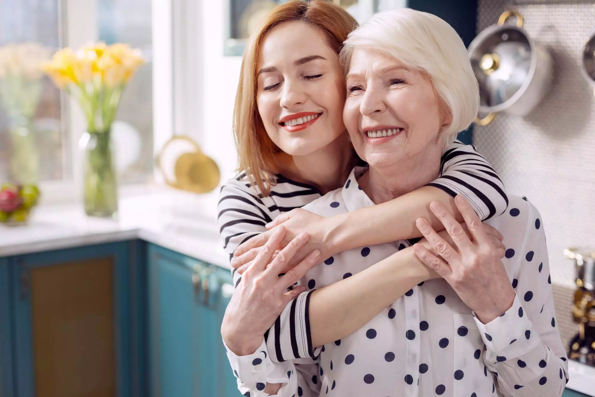 A woman is hugging her mom in a nursing home.