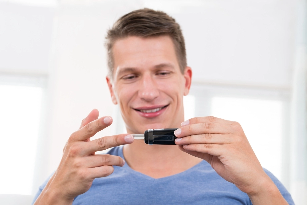 a man is checking his blood sugar levels