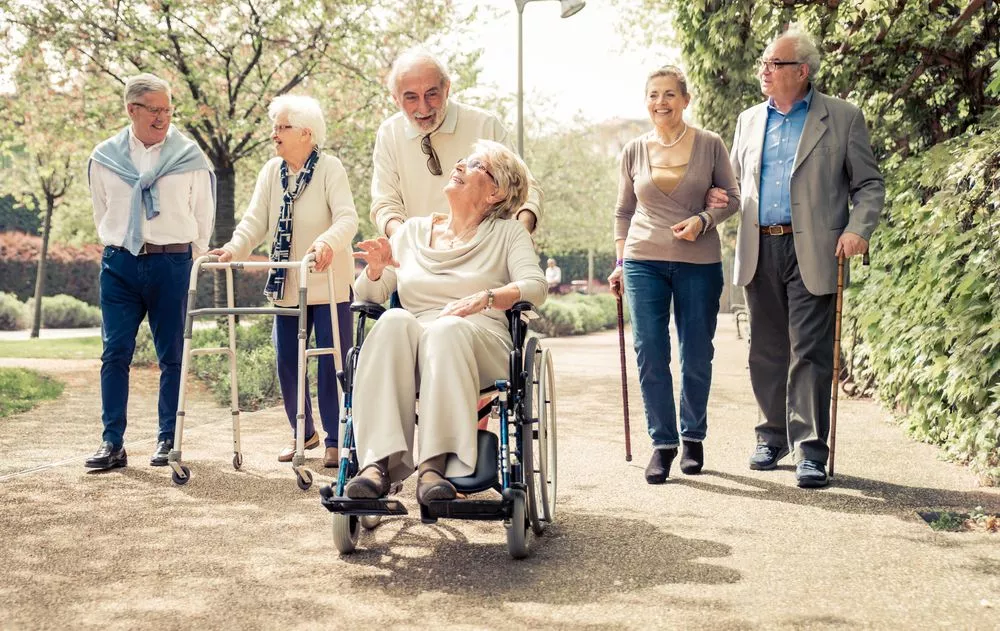 Senior citizens using different mobility devices on a walk.