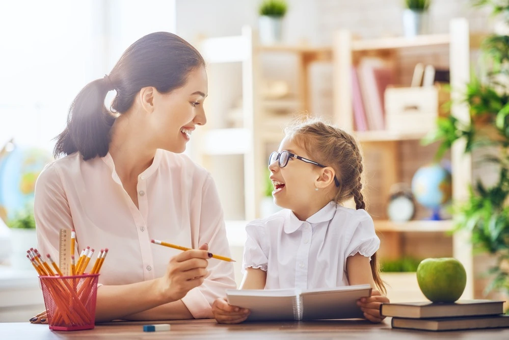 Young student smiling at her teacher