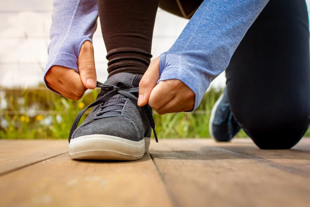 A person tying an athletic shoe`