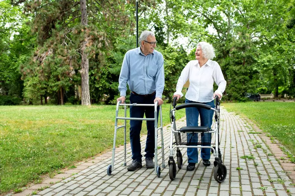 A senior couple walking with a mobility device