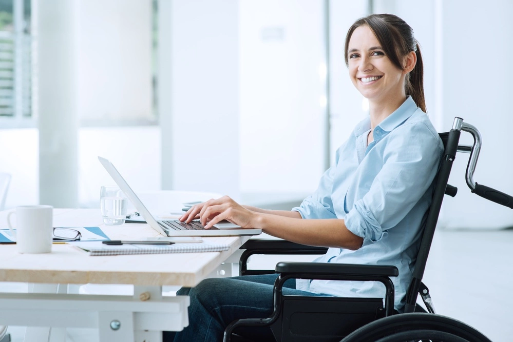 A woman in a wheelchair working at her desk